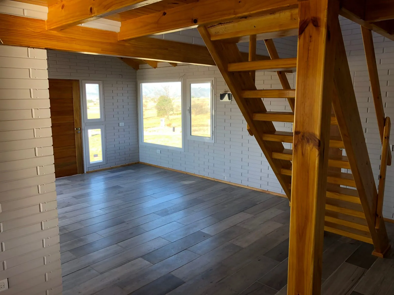Bright white interior with staircase and large windows